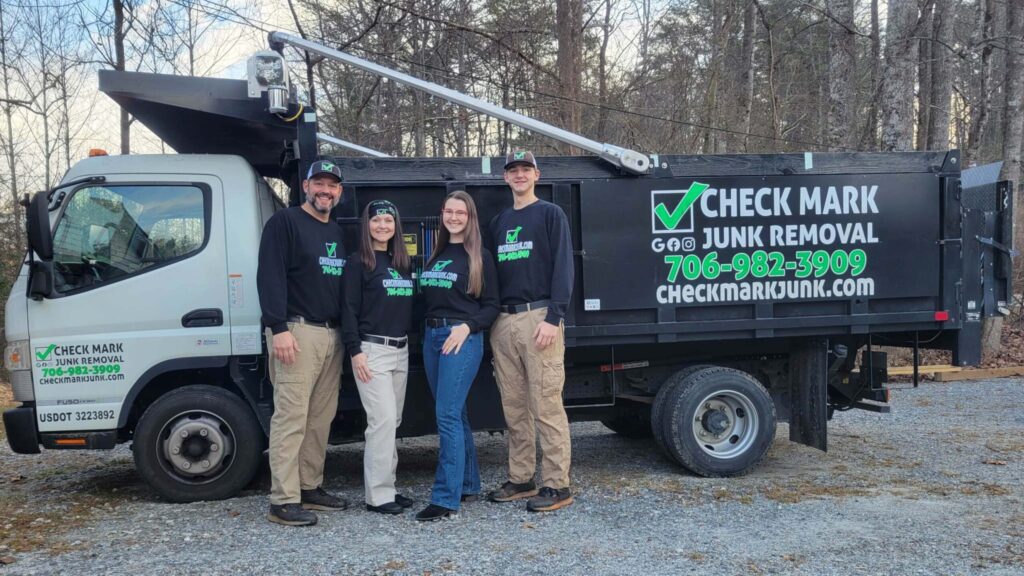 Check Mark Junk Removal owner operators - We took this family photo with our new custom-built dump truck for The Laurel of Northeast Georgia article