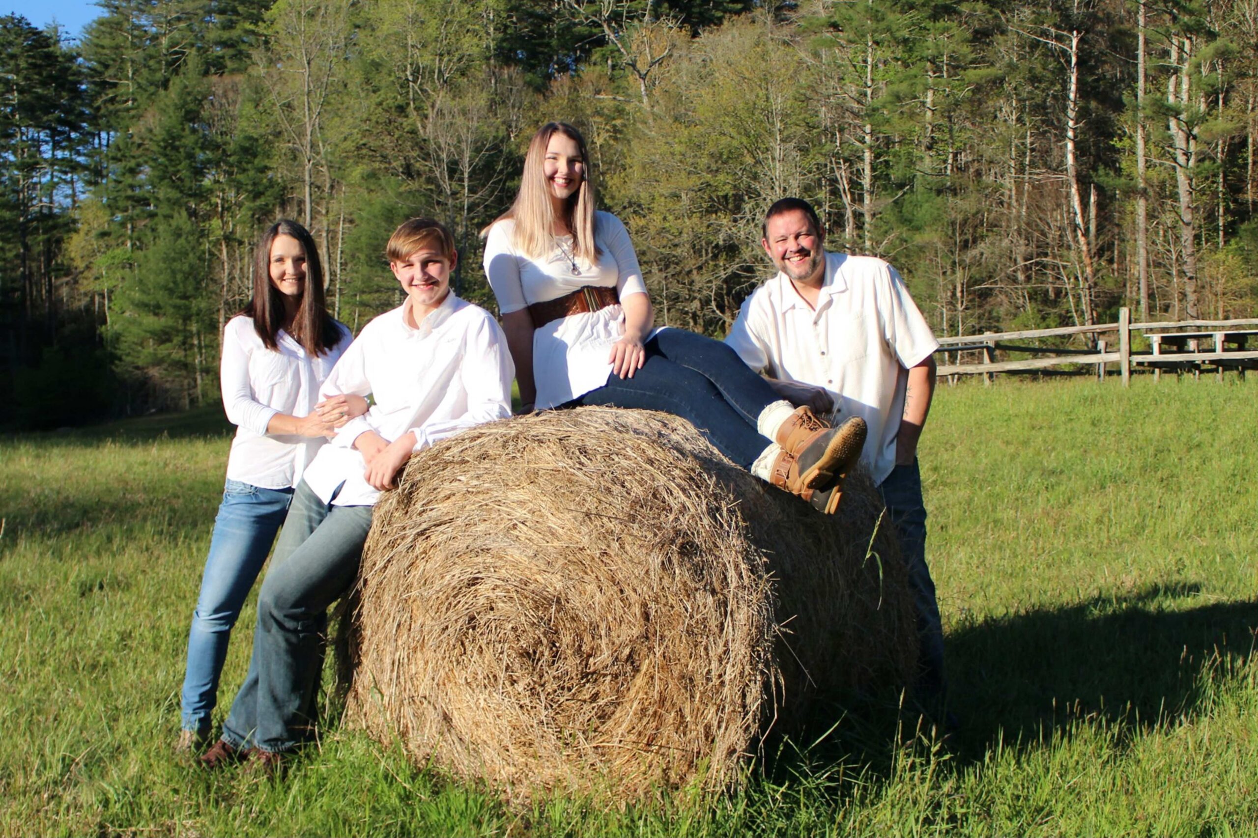 Check Mark Junk Removal owners family photo with round hay bale